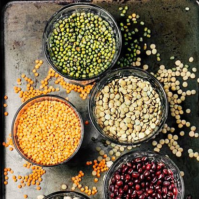 variety of legumes in glasses on metal background