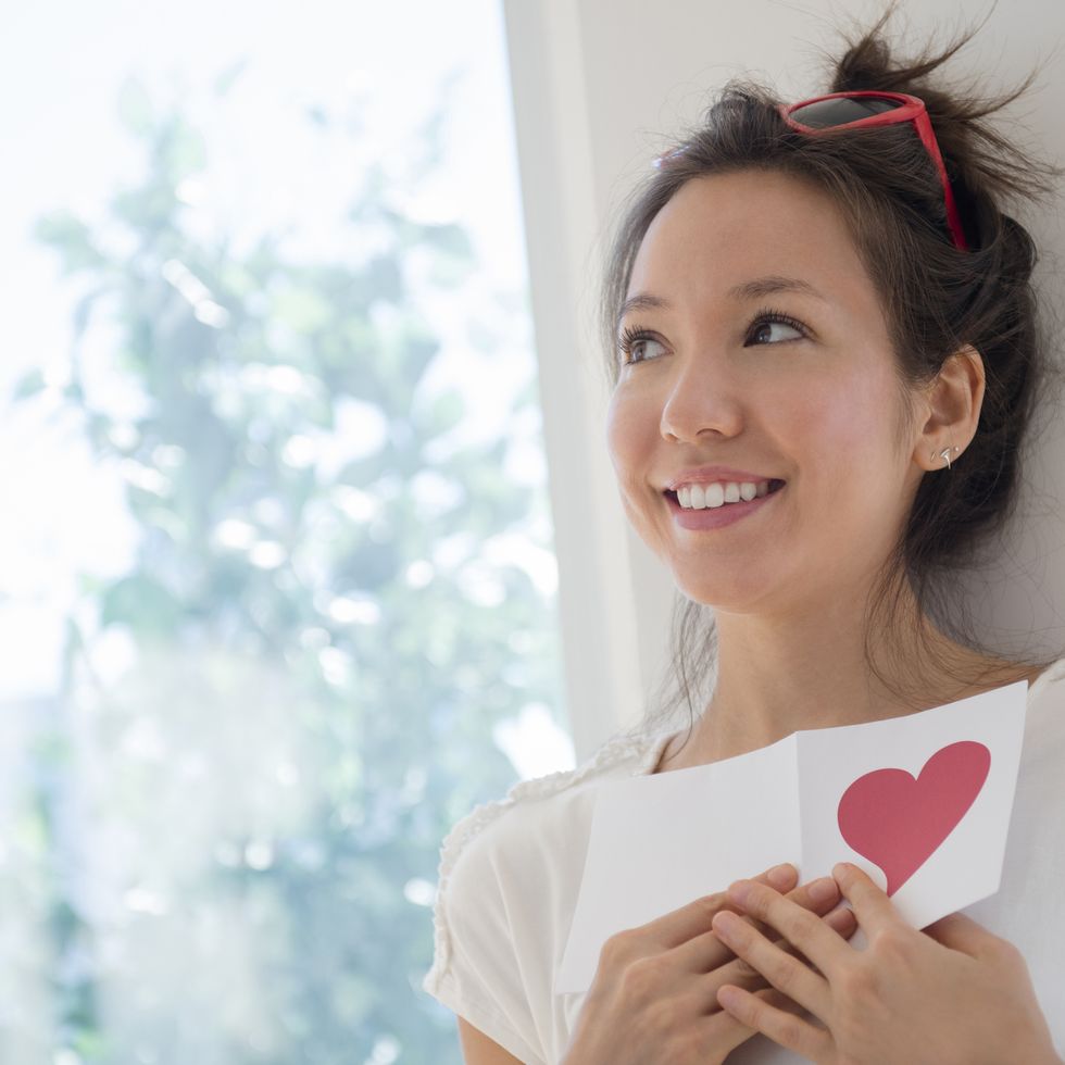 a woman holding a valentine card