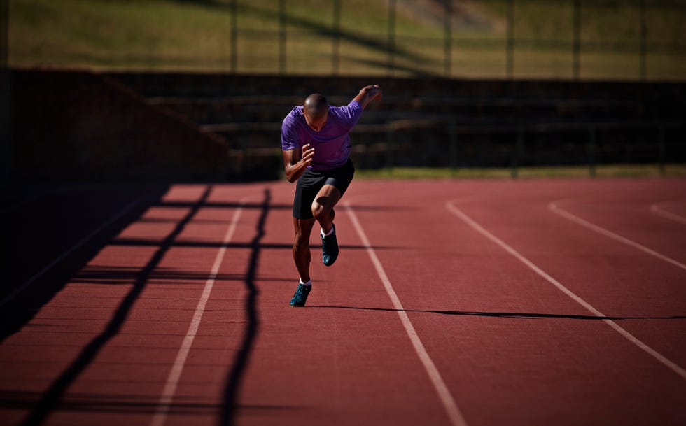 male runner sprinting at stadium