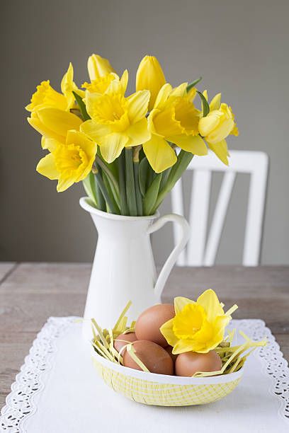 daffodils narcissus in a jug, easter decoration with brown eggs