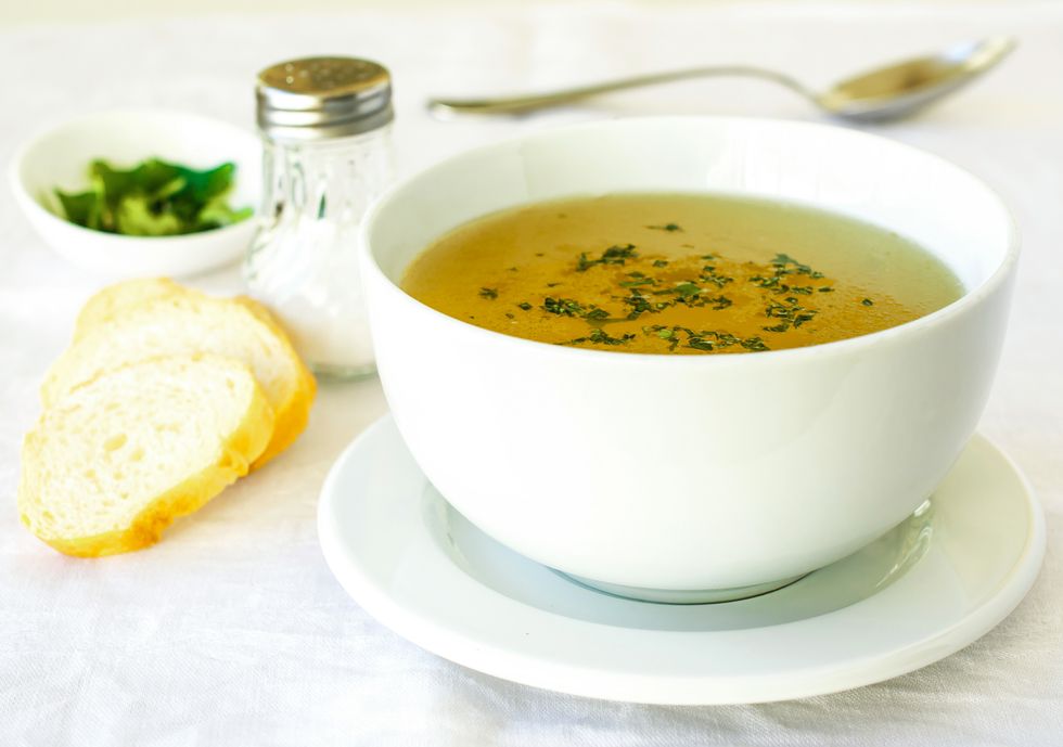 chicken broth with parsley, served in white bowl