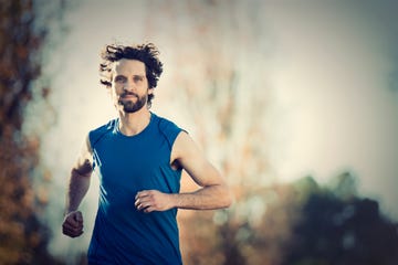 Runner in a blue tank top jogging outdoors