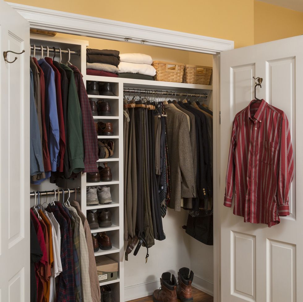 mens clothes closet in bedroom organized in home with shoes