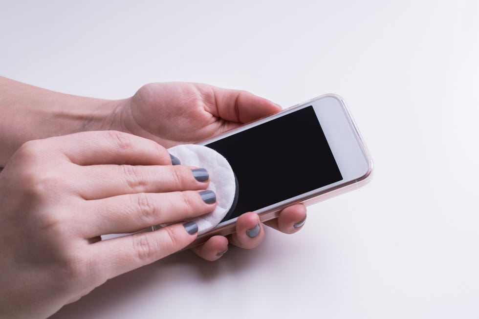 Woman hand cleaning mobile phone display