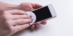 Woman hand cleaning mobile phone display