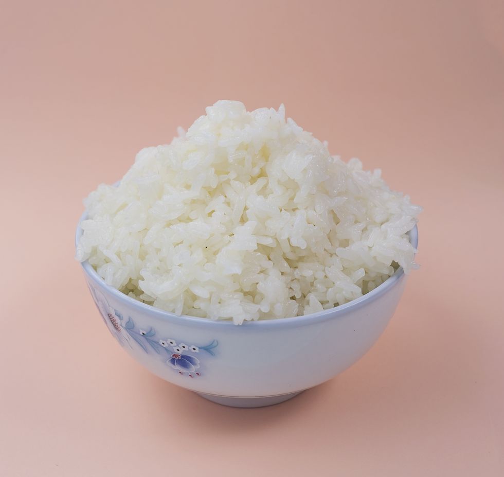 White rice in china bowl on pink background