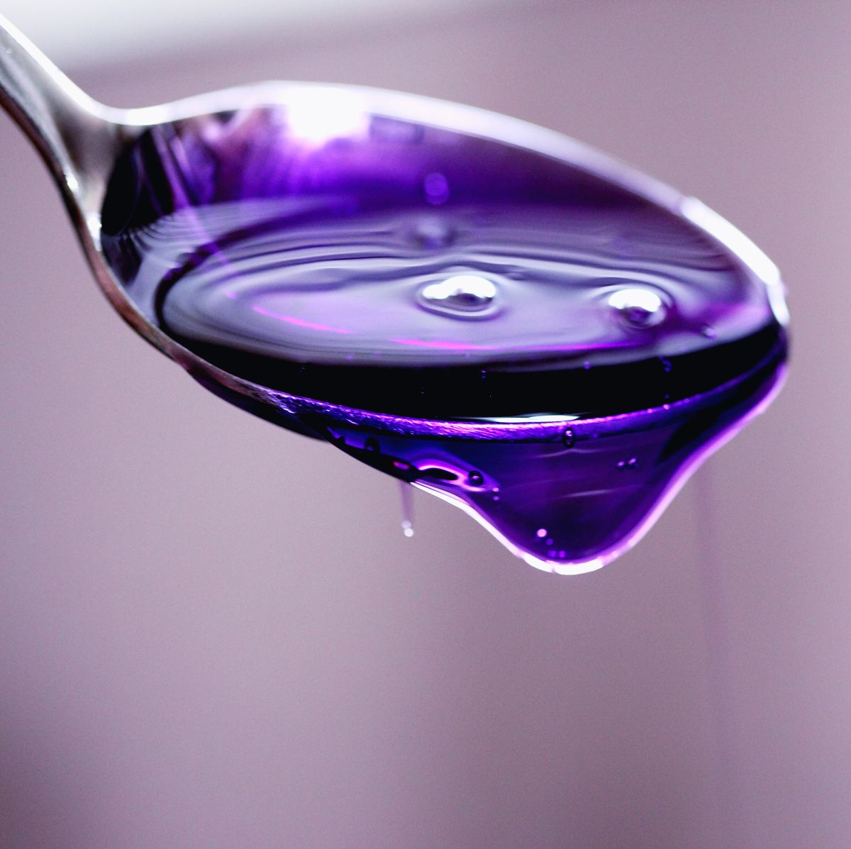 Close-Up Of Purple Medicine Syrup In Spoon