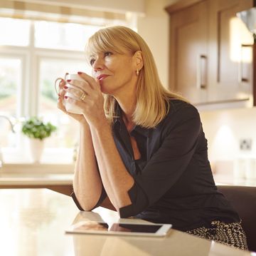 signs of a midlife crisis for women woman holding a coffee cup and looking into the distance