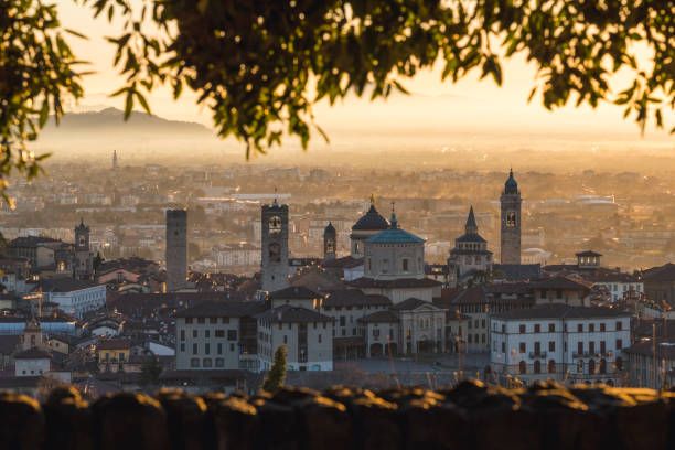the upper towns città alta skyline with bell towers and the cathedrals cupola at sunrise bergamo, lombardy, italy