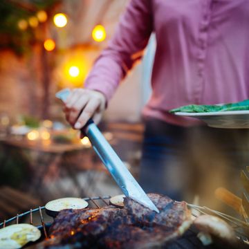 woman barbecuing with open flame grill outdoor