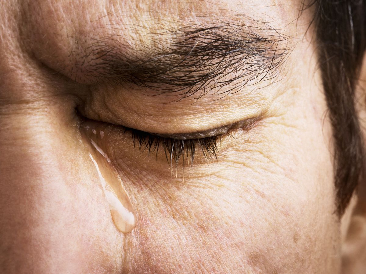 Distress And Suffering With A Human Eye Crying A Single Tear Drop With A  Screaming Facial Expression Of Anguish And Pain Due To Grief Or Emotional  Loss Or Business Burnout Stock Photo
