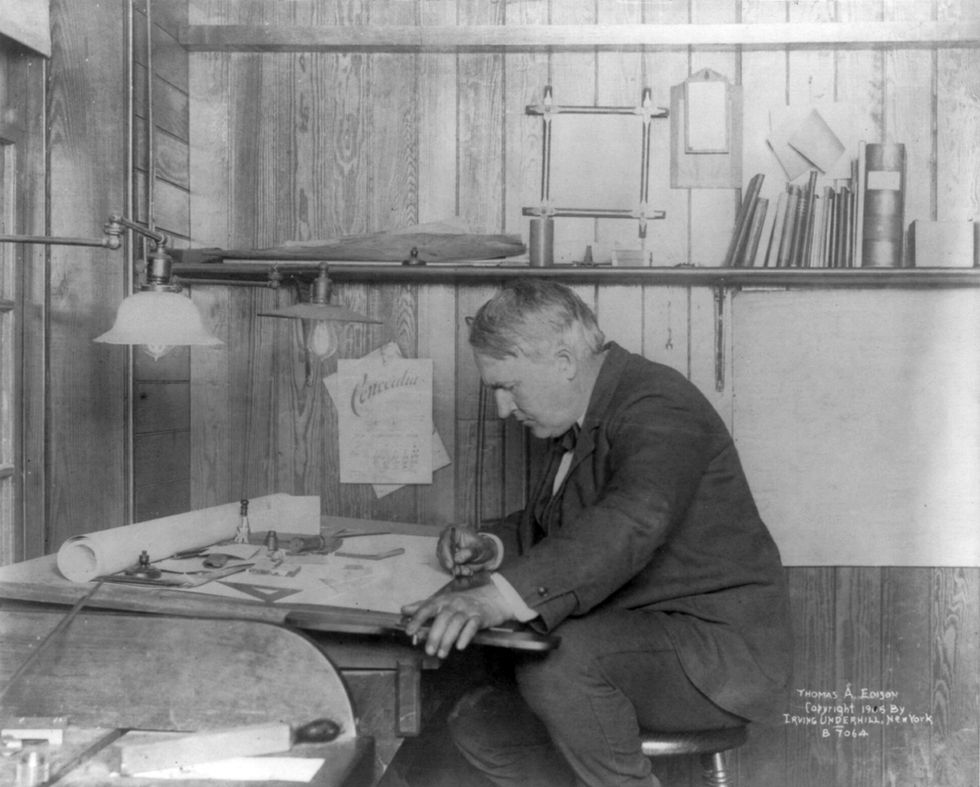 thomas edison seated at his desk writing in 1905