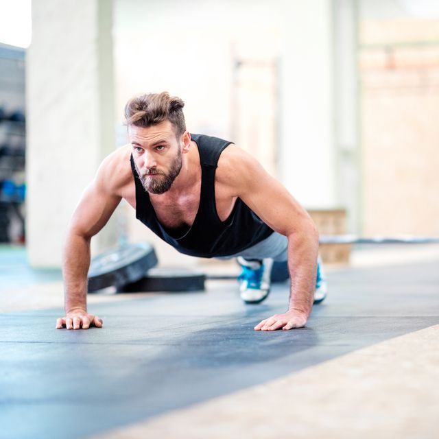 muscular man making push ups at the gym gym