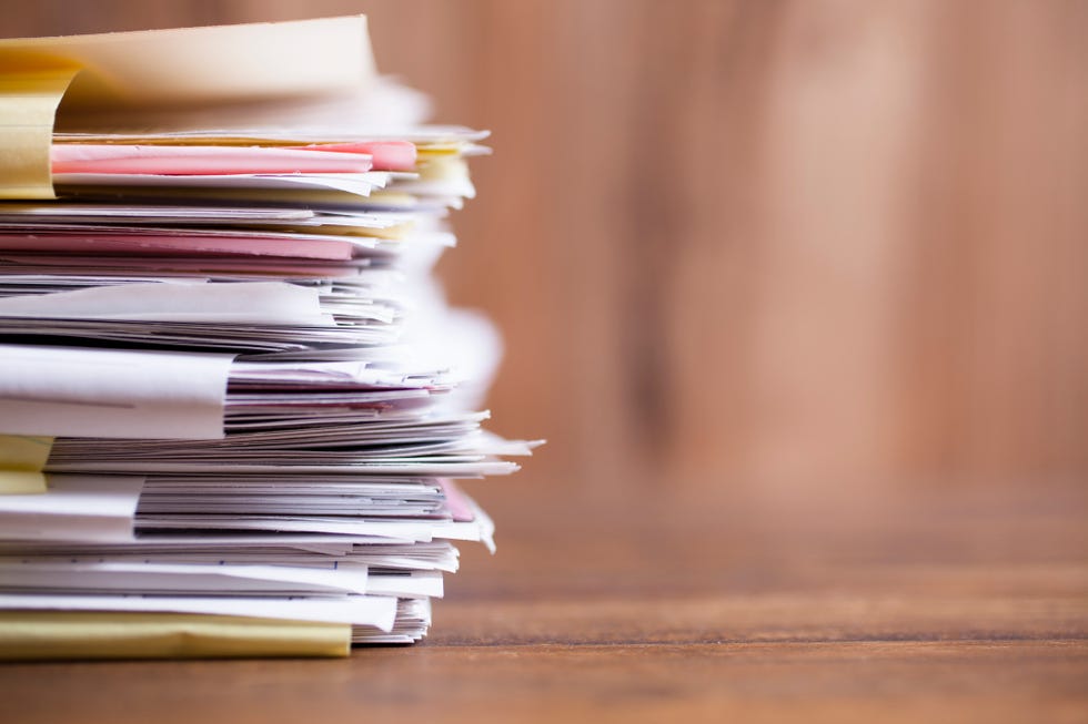 large stack of files, paperwork on office desk with copyspace overworked concept