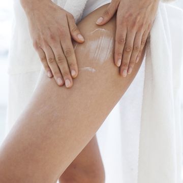 model released woman applying moisturiser to her thigh
