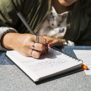 midsection of businesswoman writing on diary in train