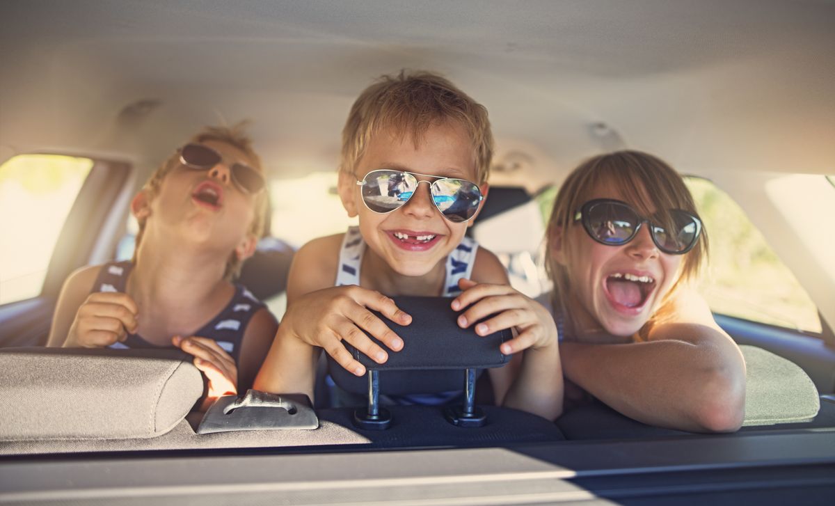 Three kids having fun on road trip
