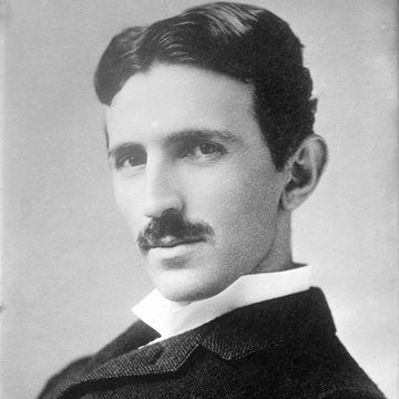 nikola tesla looks at the camera while turning his head to the right, he wears a jacket and white collared shirt