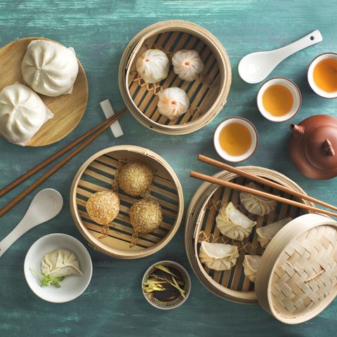 overhead view chinese food assorted dim sum food in bamboo steamer tray on rustic green table top chinese style breakfast with tea
