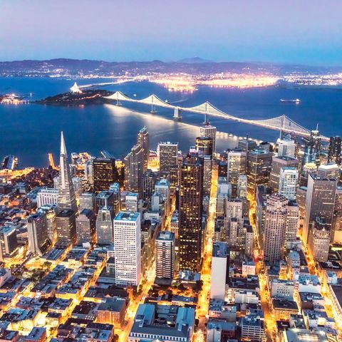 aerial of downtown district bay bridge and oakland in the background at dusk, san francisco, california, usa