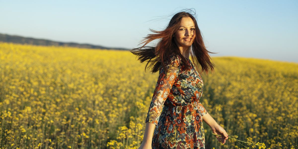 Portrait of smiling young woman standing in a rape field