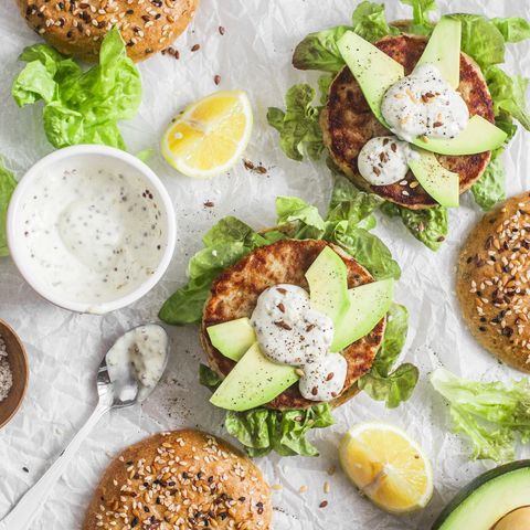 Tuna burger on a light background, top view. Burger with tuna, avocado and mustard sauce, delicious appetizer or snack