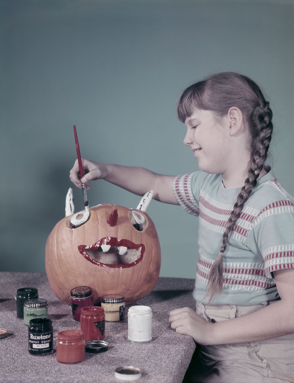 girl painting halloween pumpkin  photo by lambertgetty images
