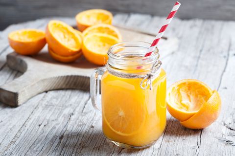 Orange Juice Squeezed In glass jar with fund rustic