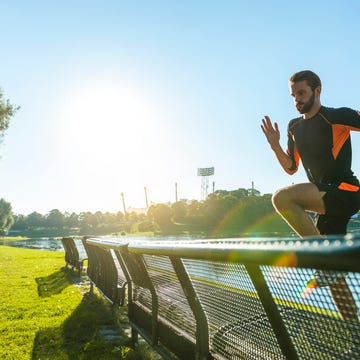 Athlete jumping over bench at the riverside a man jumping on a trampoline