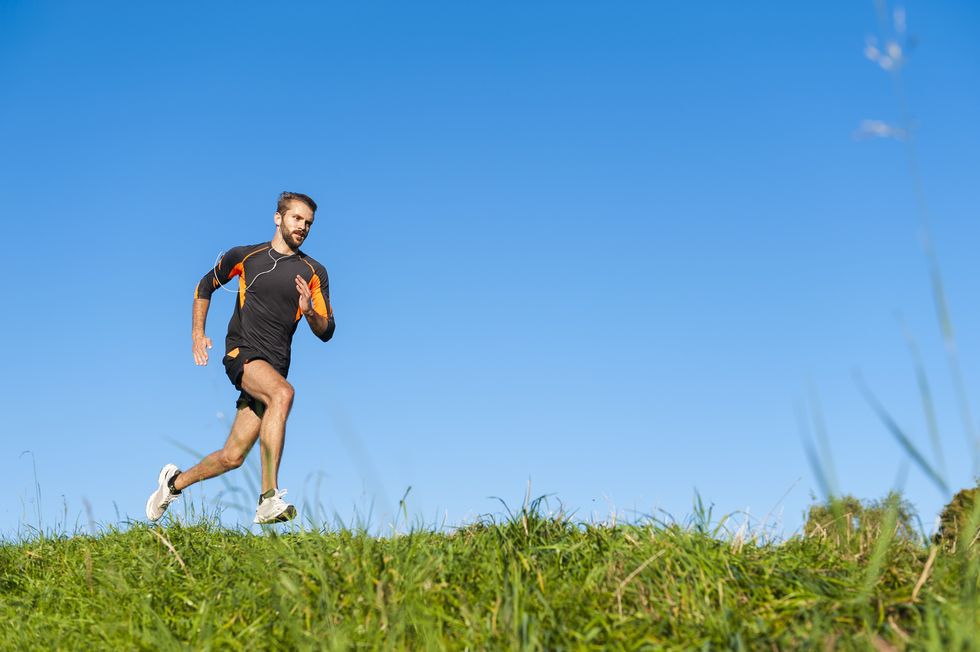 a man running on a grassy hill