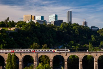 a train on the pafendaller viaduc railway bridge and the modern high rise buildings on the kirchberg plateau luxembourg city, luxembourg