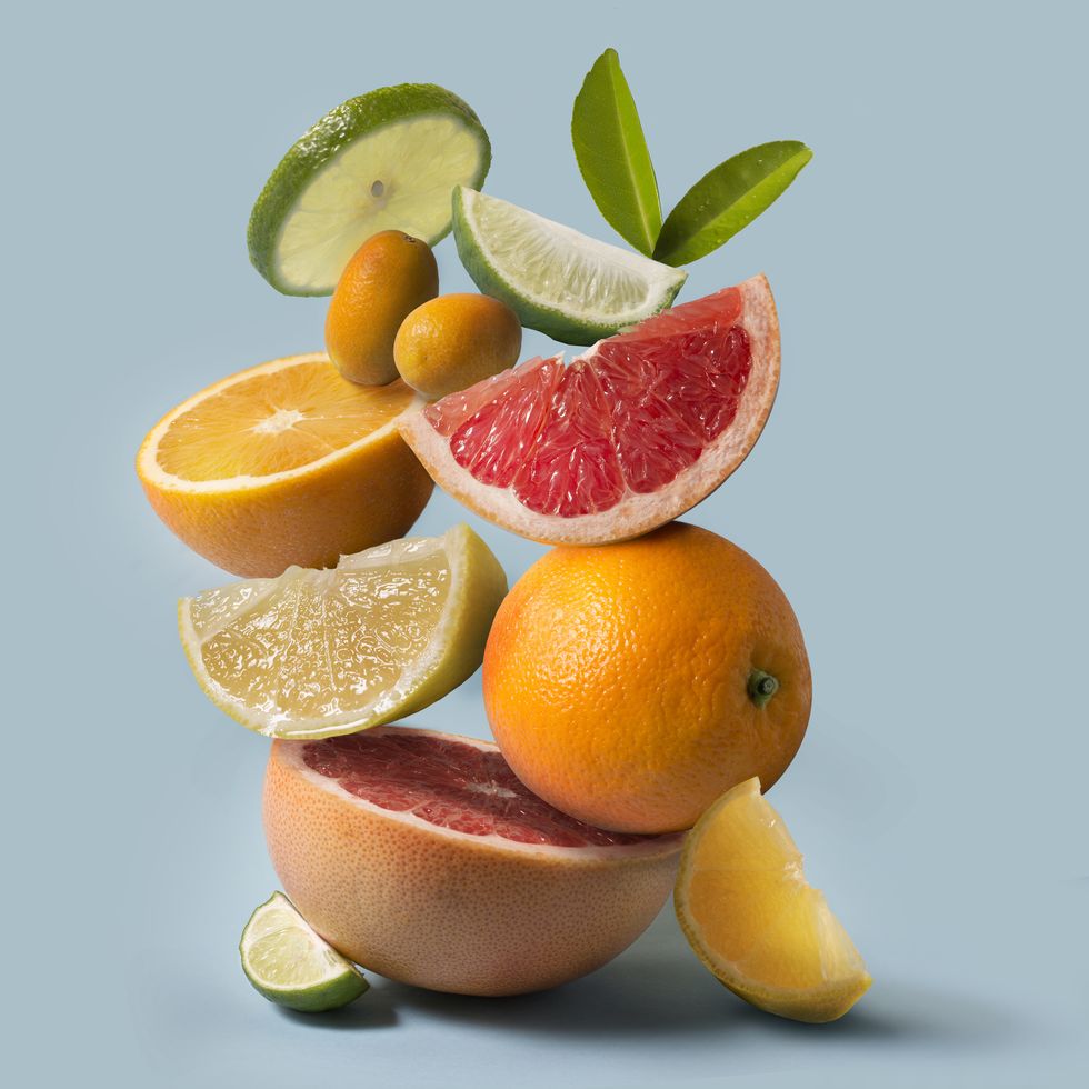 assorted citrus fruits still life on light blue background close up view