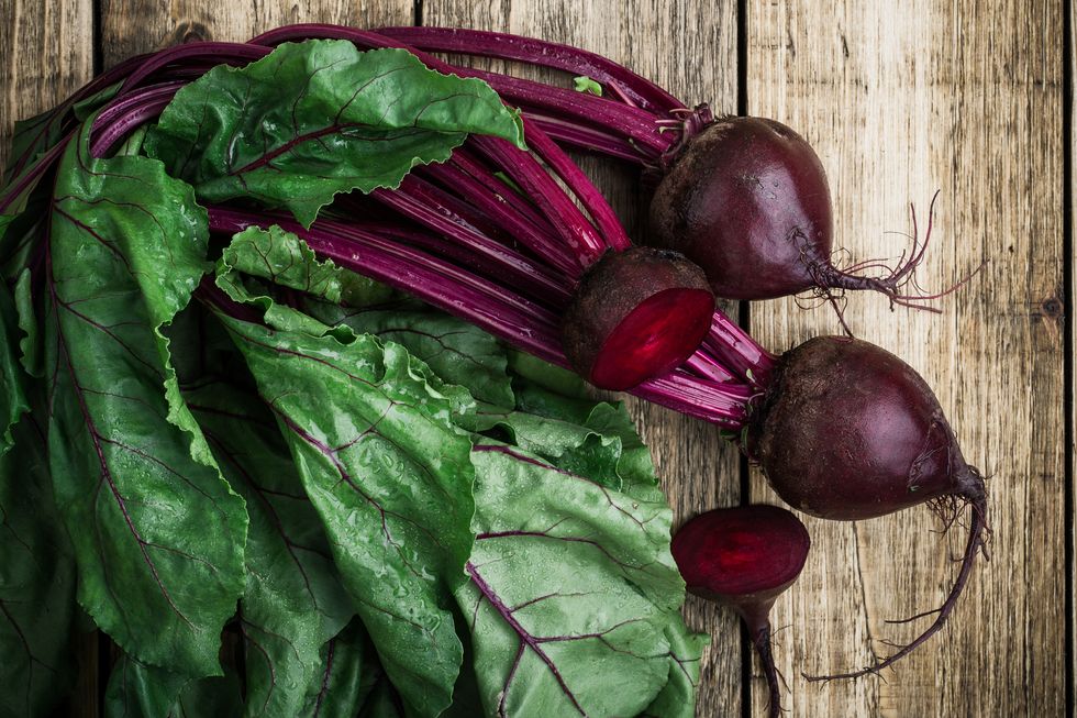fresh organic beetroot over wooden background viewed from above
