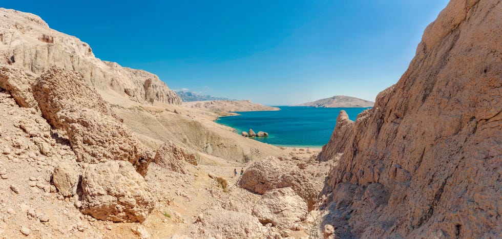 tourists walking towards beritnica beach near metajna, pag island, croatia
