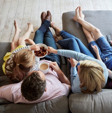 A family at home. View from above of two adults and two children seated on a sofa together. a family at home view from above of two adults and two children seated on a sofa together