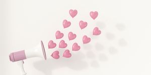 Megaphone with pink heart-shaped balloons as sound waves, 3d rendering