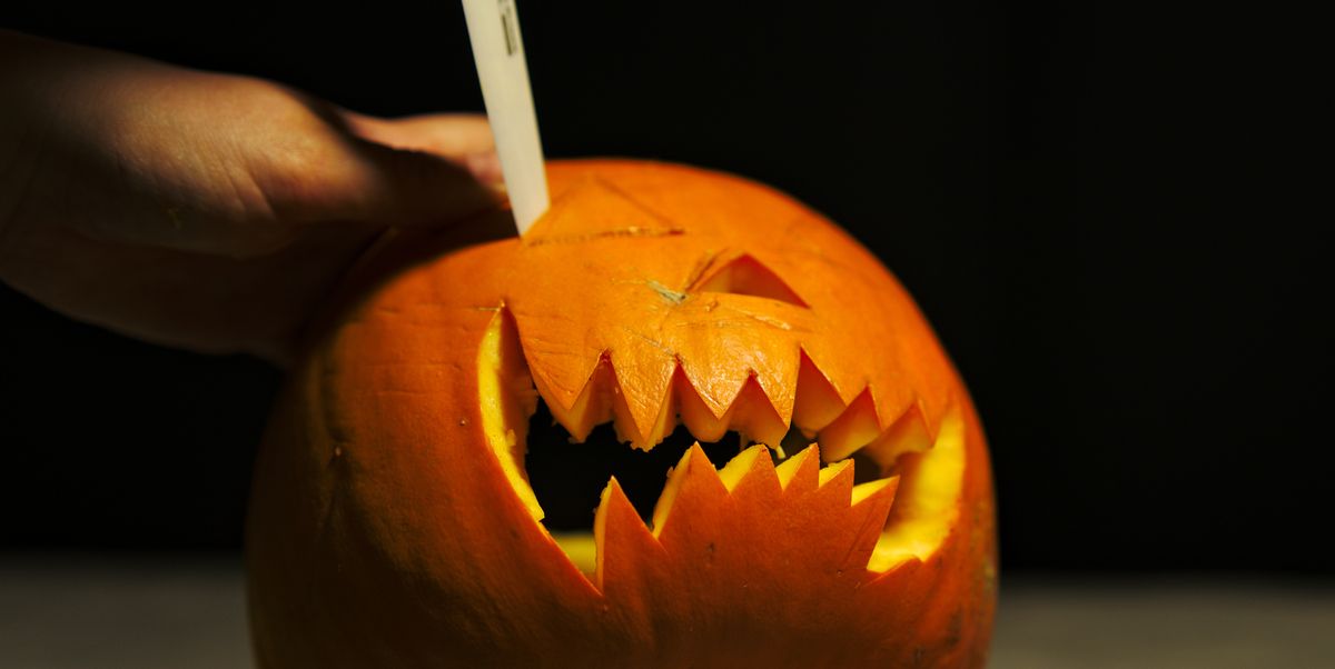 Cropped Image Of Person Carving Pumpkin At Table