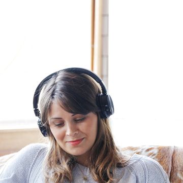 young woman listening to headphones and looking at a smartphone