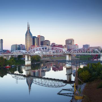 the skyline of nashville, tennessee reflected in the cumberland river at sunrise