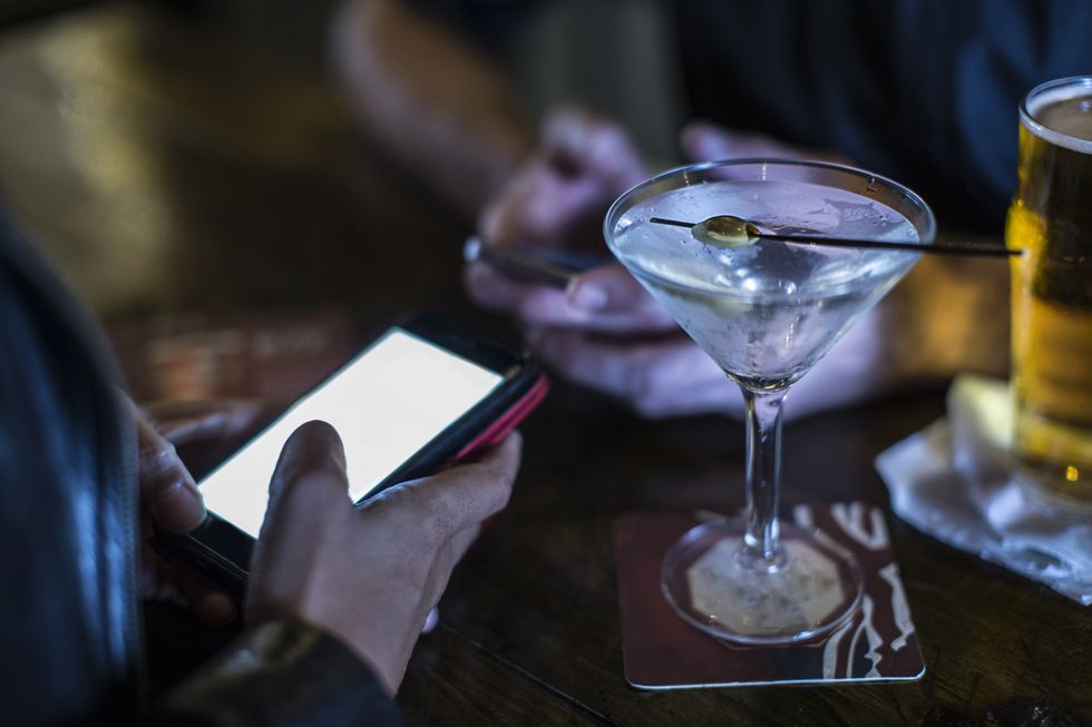 Close up of female hand using smartphone in public house