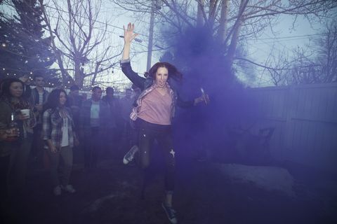 Woman running through blue smoke