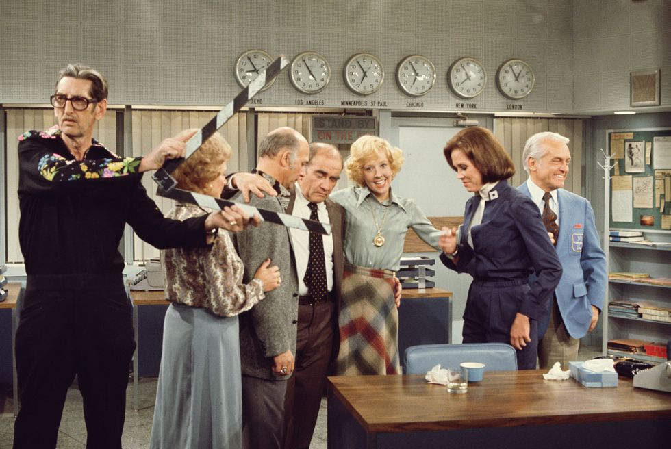 american actors second left to right betty white, as sue ann nivens, gavin mcleod, as murray slaughter, ed asner, as lou grant, georgia engel, as georgette franklin baxter, mary tyler moore, as mary richards, and ted knight 1923 1986, as ted baxter, embrace one another beyond an unidentified crewmember with a slate on the set of the cbs situation comedy mary tyler moore during the filming of the final episode, last show, studio city, los angeles, california, march 19, 1977 photo by cbs photo archivegetty images