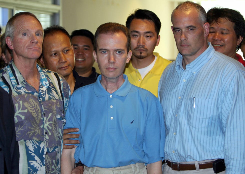 Bangkok, Thailand Photo dated August 17, 2006 shows teacher John Mark Karr C surrounded by us and Thai security officers at the Thai Immigration Department in Bangkok. Thai police prepared on August 19, 2006 to deport Karr, arrested for more than a decade for the murder of child beauty queen Jonbenet Ramsey amid doubts whether he really killed the girl or was merely obsessed with her death afp photo saeed khan photo credit should read saeed khanafp via Getty Images