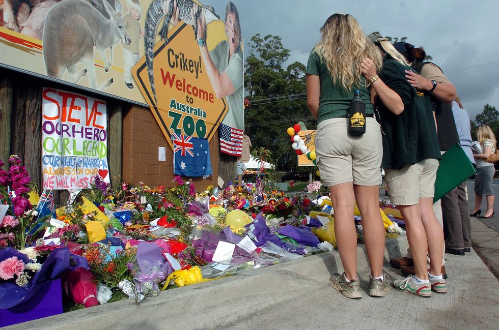Staff members from the Australia Zoo console each other as they observe tributes outside the zoo on September 6, 2006, following the death of Steve Irwin