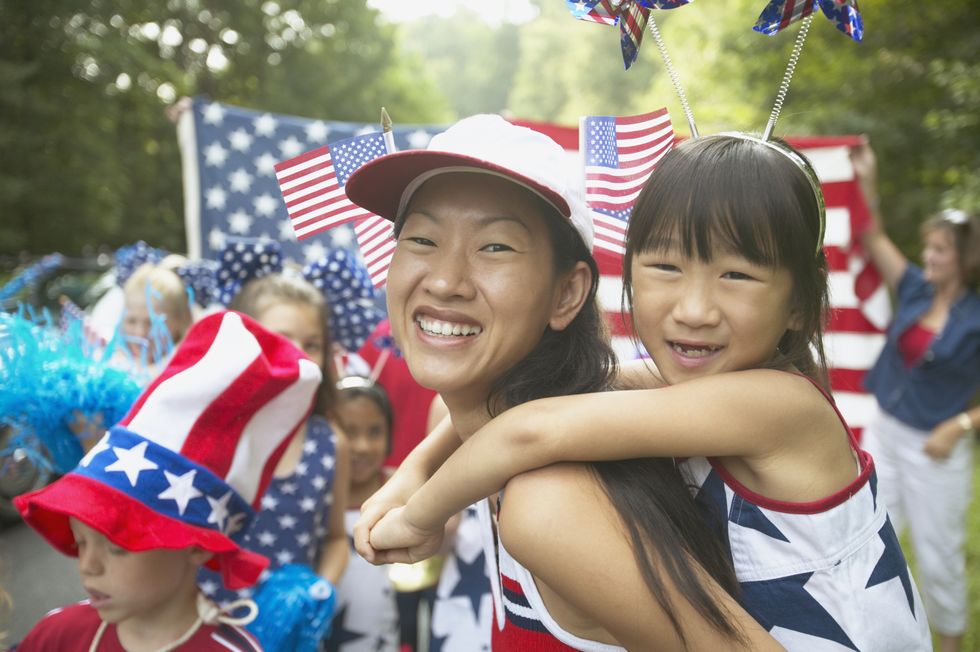 asian mother and daughter in fourth of july parade