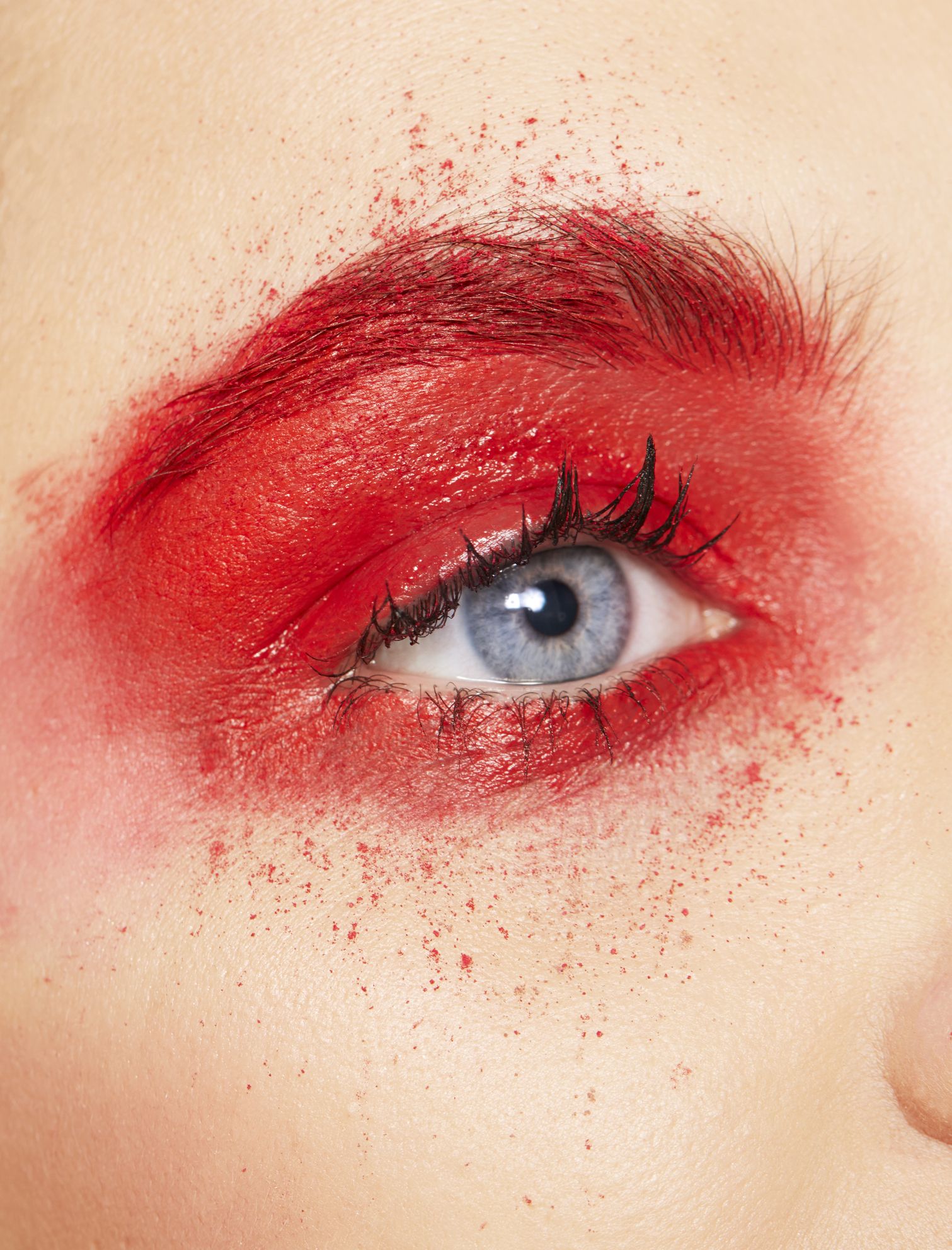 Close up of young womans eye with red eye shadow