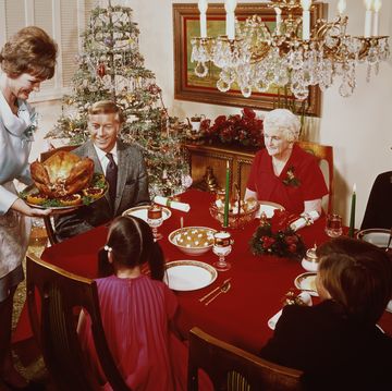 a mother bringing a large turkey to the table for christmas dinner, circa 1965 photo by l willingerfpghulton archivegetty images