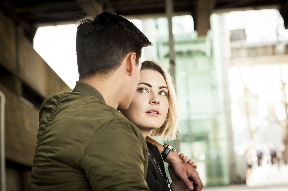 young couple, underneath bridge, face to face, pensive expression