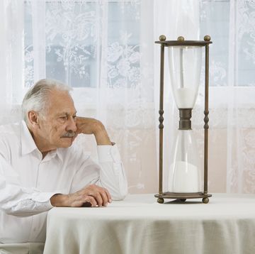 een oude man en vrouw kijken naar een zandloper