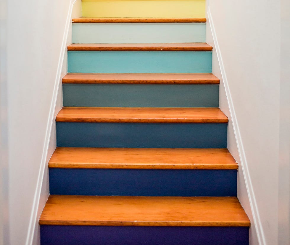 Caucasian mother and daughter climbing multicolor staircase